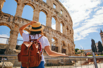Amphitheater von Pula in Kroatien – Touristin vor der historischen Arena, beliebte Sehenswürdigkeit bei einer Rundreise durch Istrien